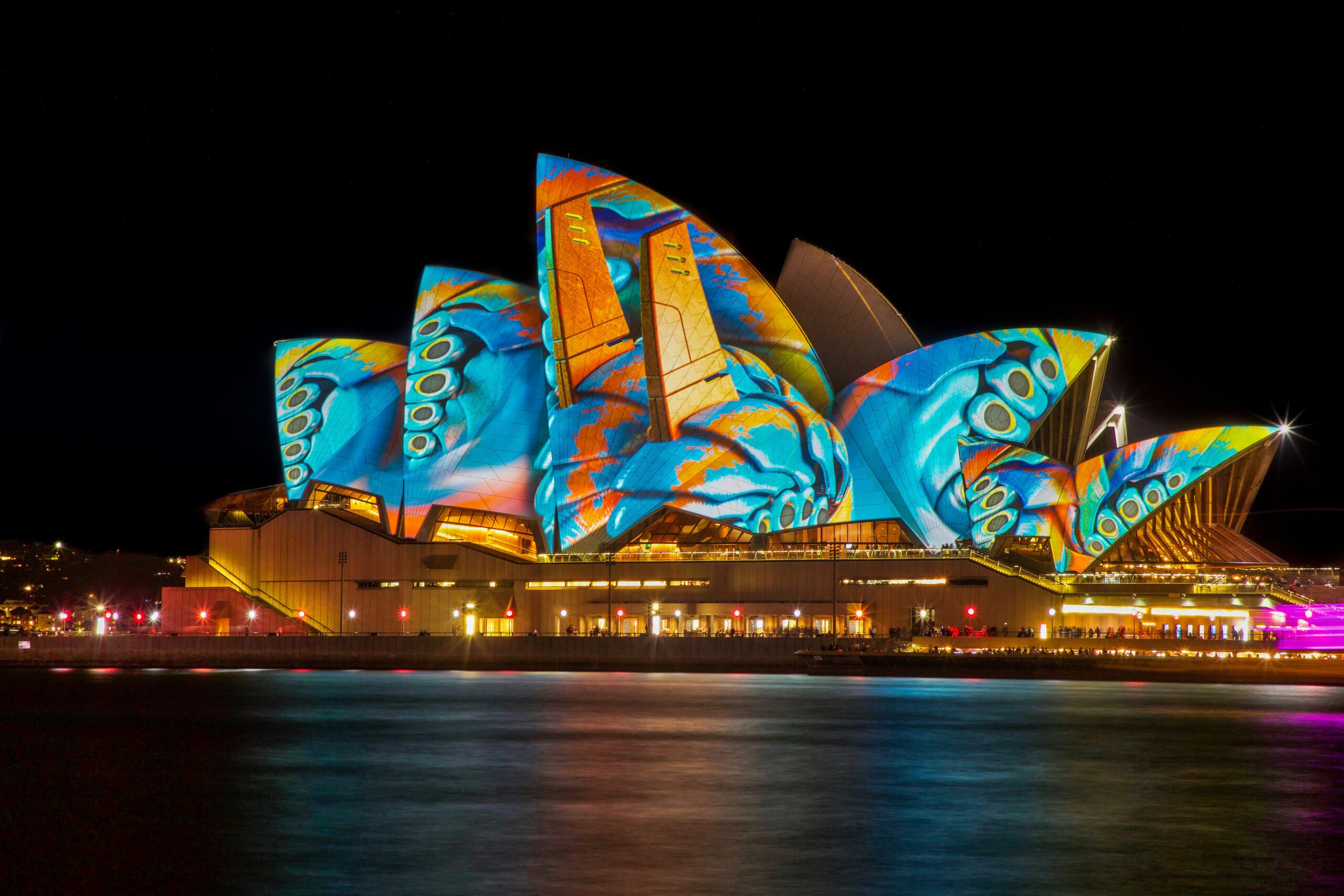 Das berühmte Opernhaus in Sydney, Australien; bunt beleuchtet.